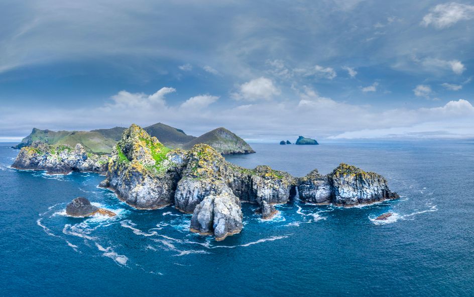 Overlooking rigorous cliff peaks in calming seawater.