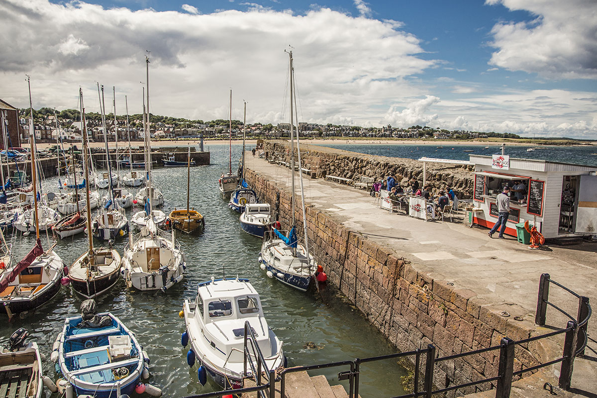 Seafood shack by a harbour with boats