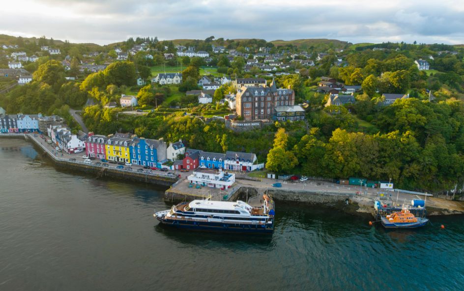 A boat docked on the water by colourful houses