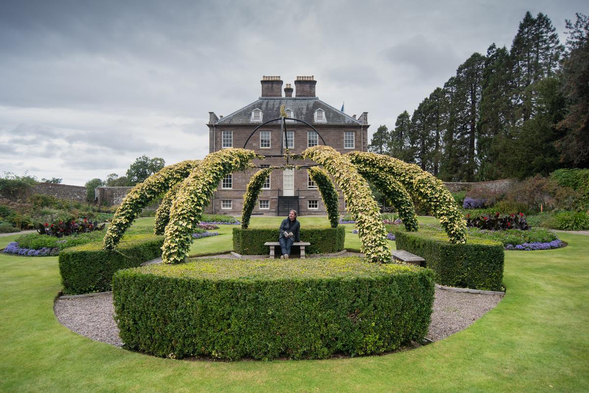 A house on a hill next to a body of water