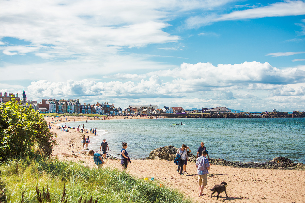 People on sandy beach on a bright sunny day.