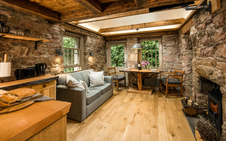 Interior of a cosy cottage with a stone walls,wood burner and sofa.