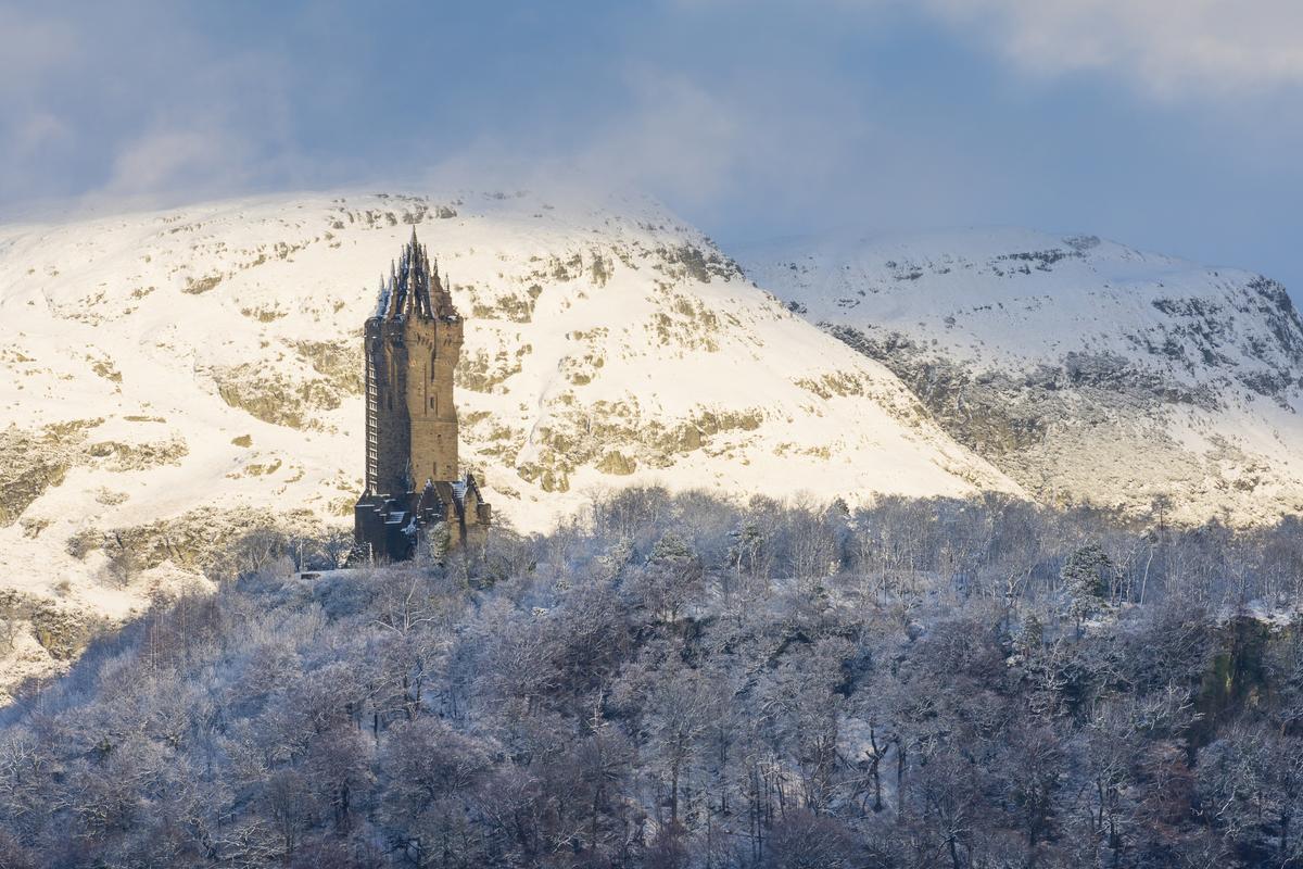 A tower on top of a mountain surrounded by snow