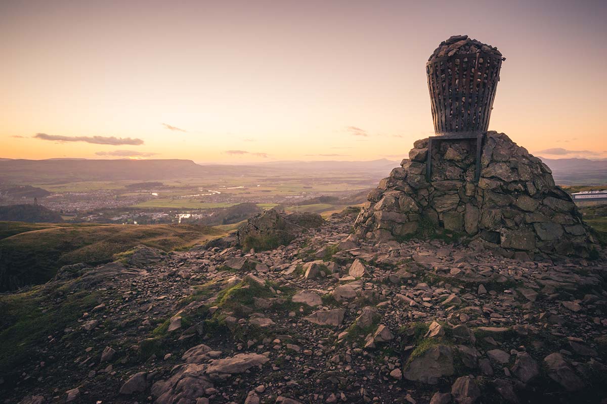 a beacon on the stony summit of Dumyat, with far reaching views over the countryside and buildings below