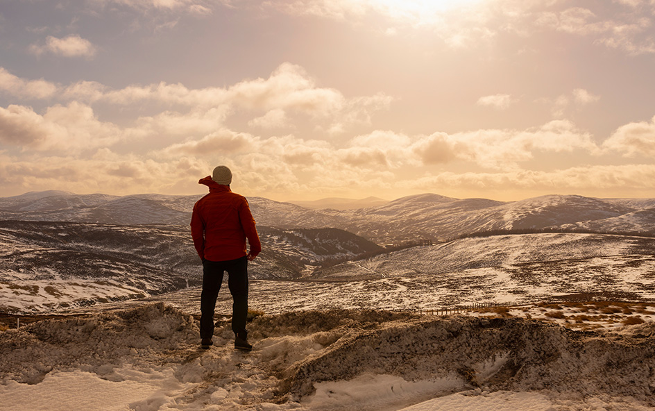 Man looking out over winter mountain scene