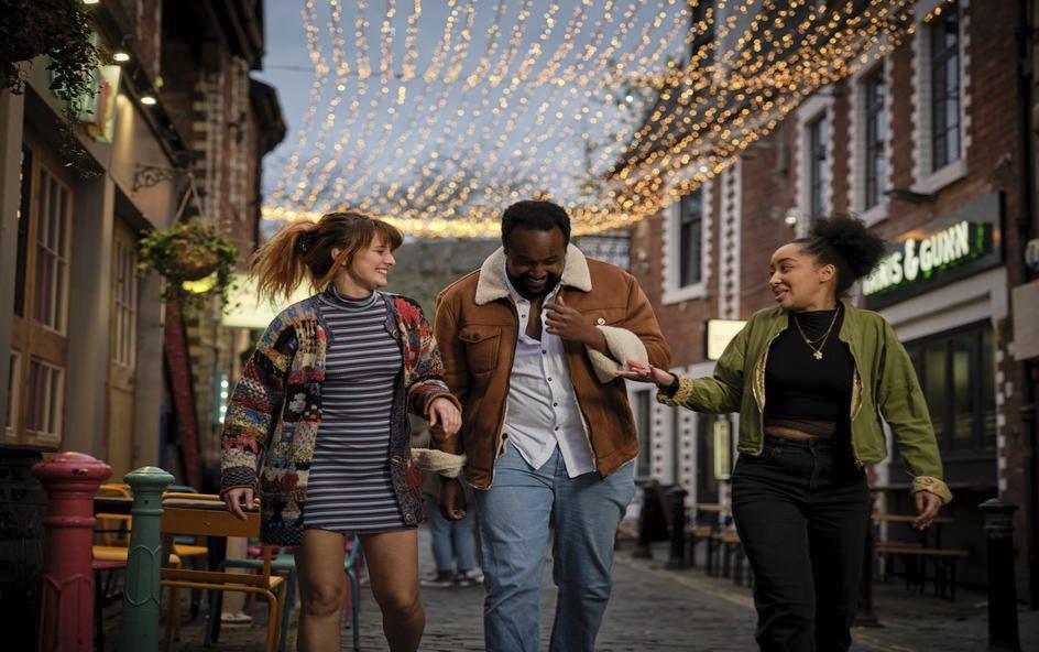 Three people walking through street