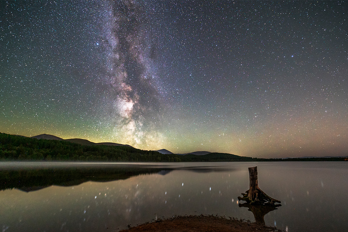 Dark starlit skies across water