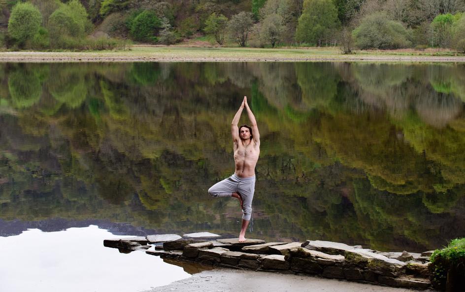 A person standing on a rock in a yoga tree pose