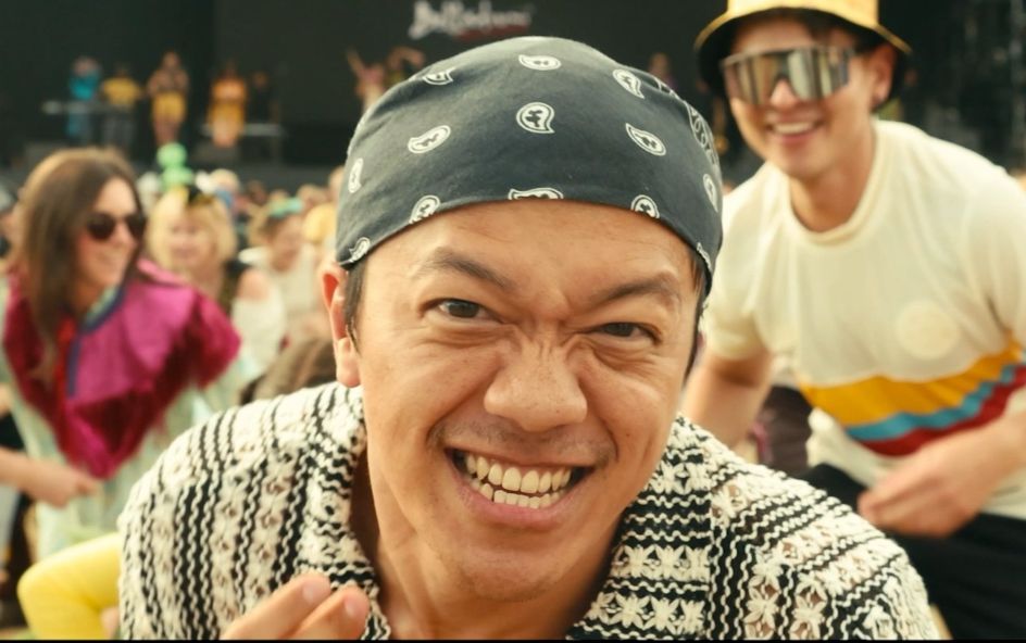 Person looking into camera with excited face with crowd in background.