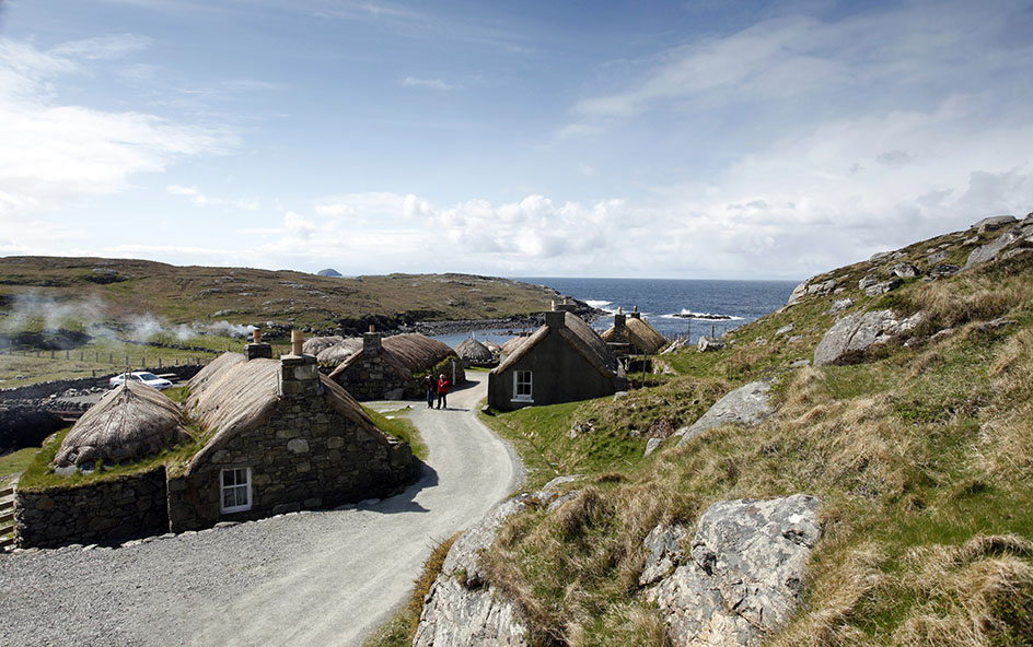 Two people walking at Gearrannan Blackhouse Village