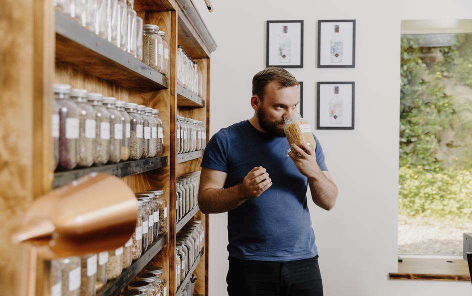 Person smelling botanicals in a jar.
