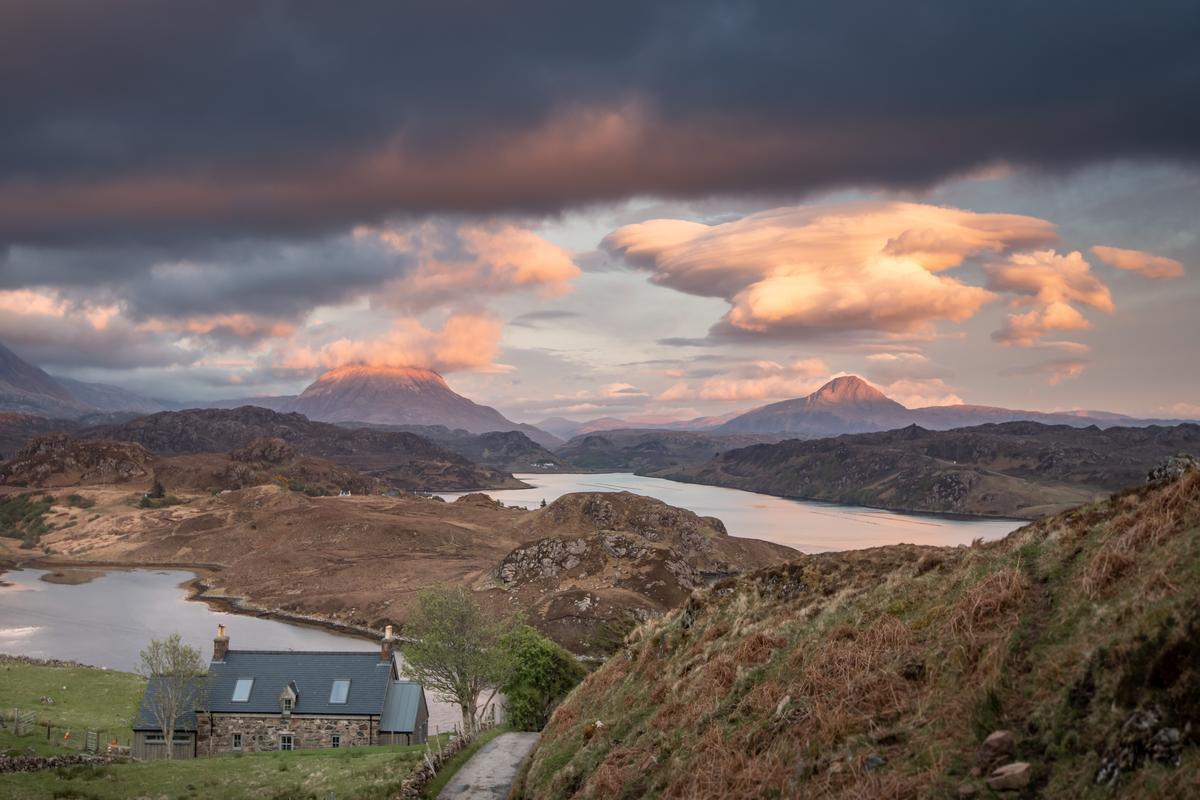 A house on a hill next to a body of water