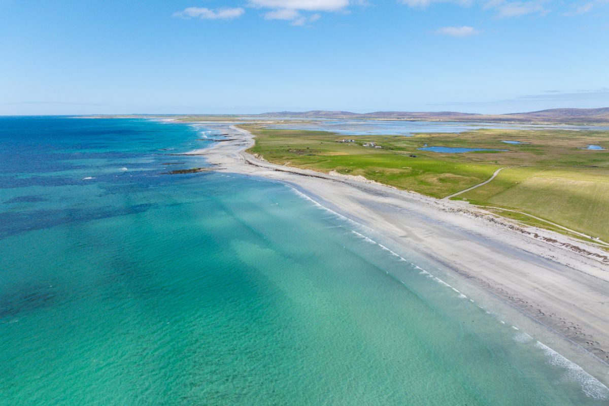 A white sandy beach with blue and green water