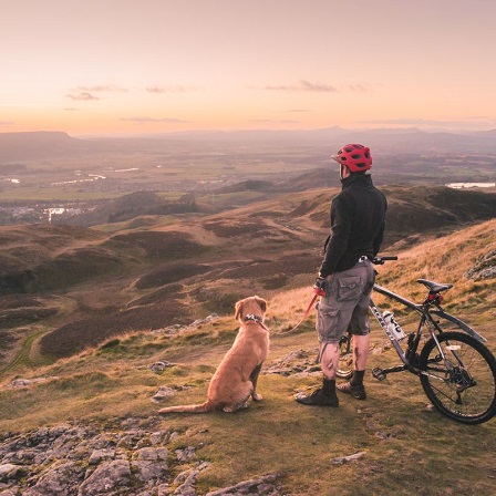 A man with his dog and bike at Dumyat, Ochil Hills. © Discover Clackmannanshire / Damian Shields