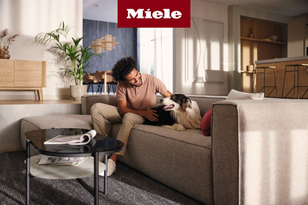 Man sitting on couch with pet dog