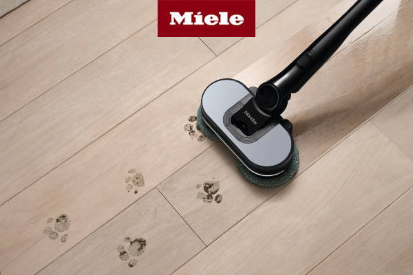 Cordless electric mop cleaning muddy pet paw prints on light wood flooring, leaving a shiny, spotless surface.