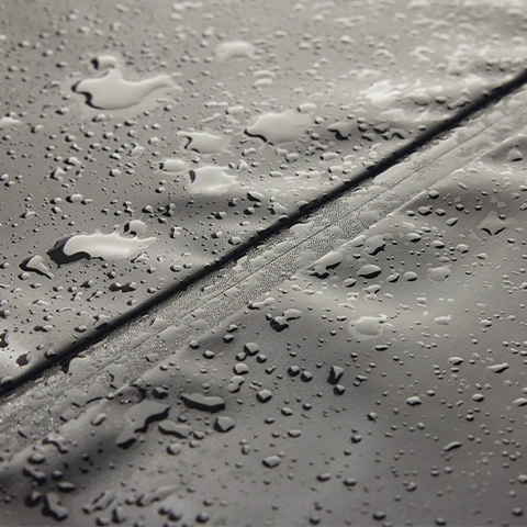 Nahaufnahme einer Abdeckhaube, auf der Regen abperlt.