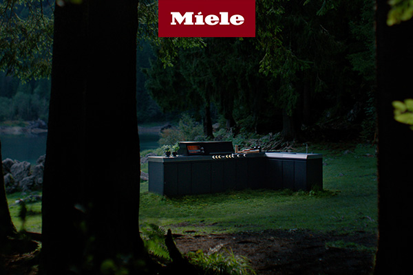 Die Miele Outdoor-Küche in einem Wald am See.