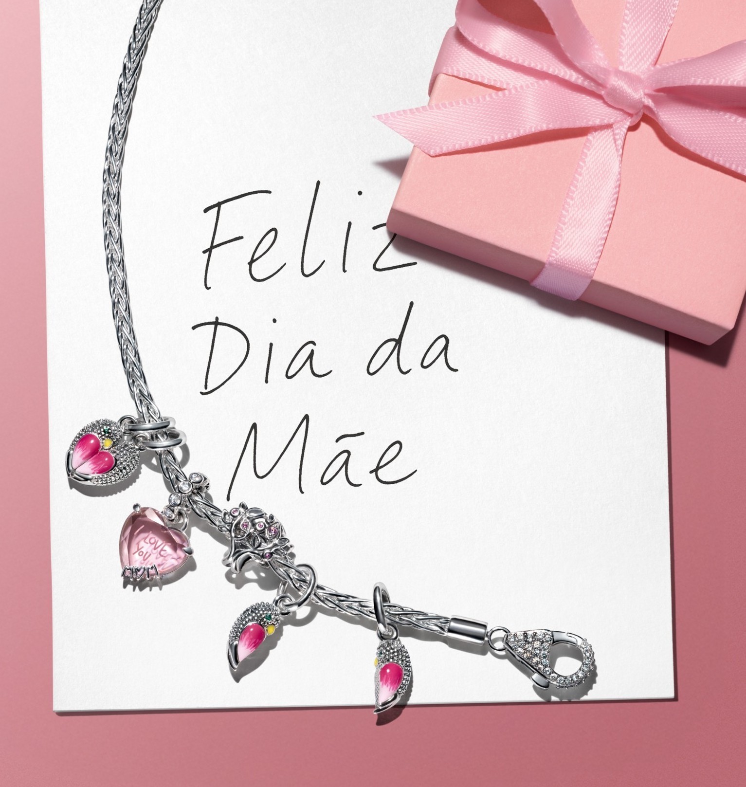 Charms styled on a bracelet over a note that says Happy Mother's Day. 