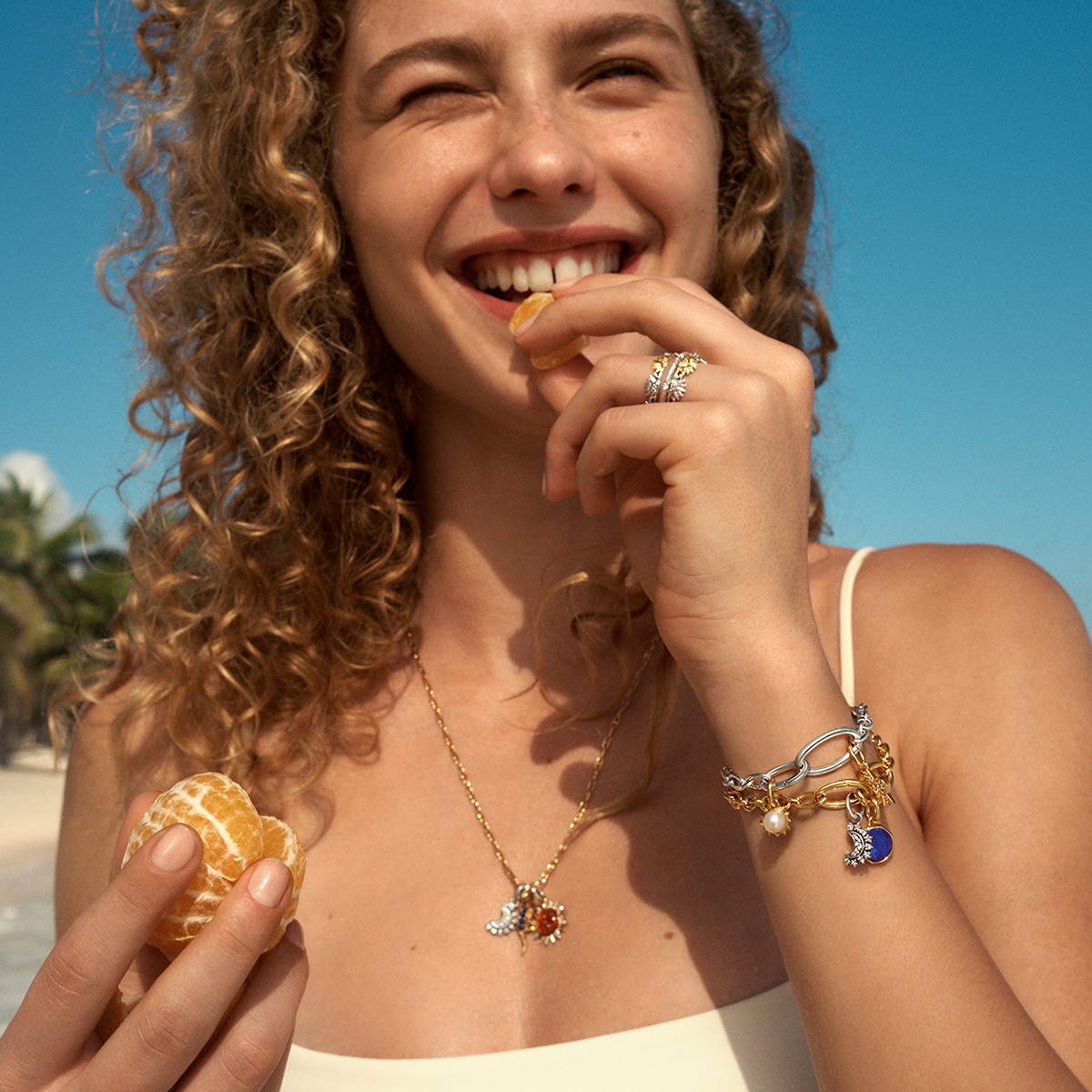 A model wears a 14k gold-plated Pandora ME link chain bracelet with charms.