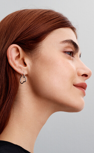 Model wears new Disney x Pandora Mickey Mouse silhouette earrings