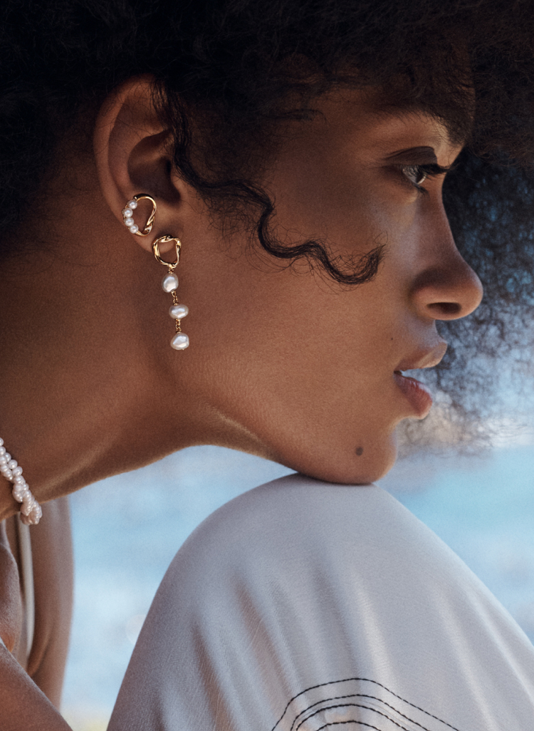 Model wears PANDORA ESSENCE pearl drop earrings