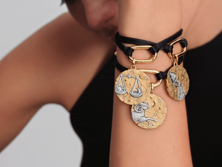 Model wears a trio of Pandora Talisman zodiac medallions.