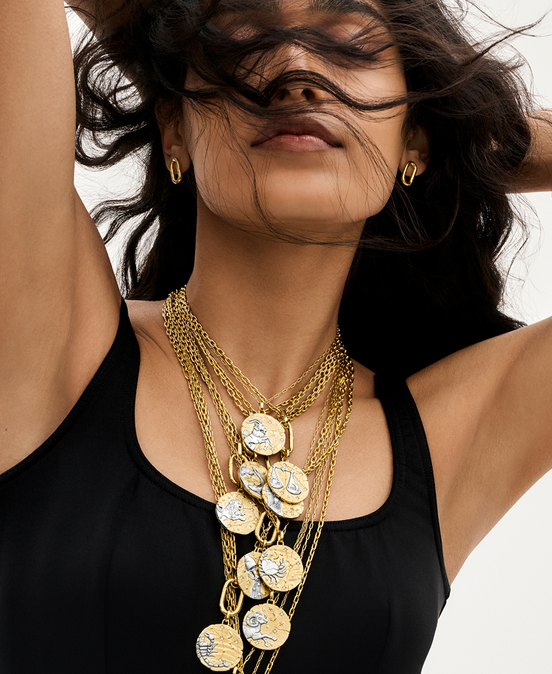 Model wears layers of Pandora Talisman zodiac medallions.