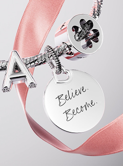 Charm bracelet stacked with letter, clover and engravable charms. Engravable charm says 