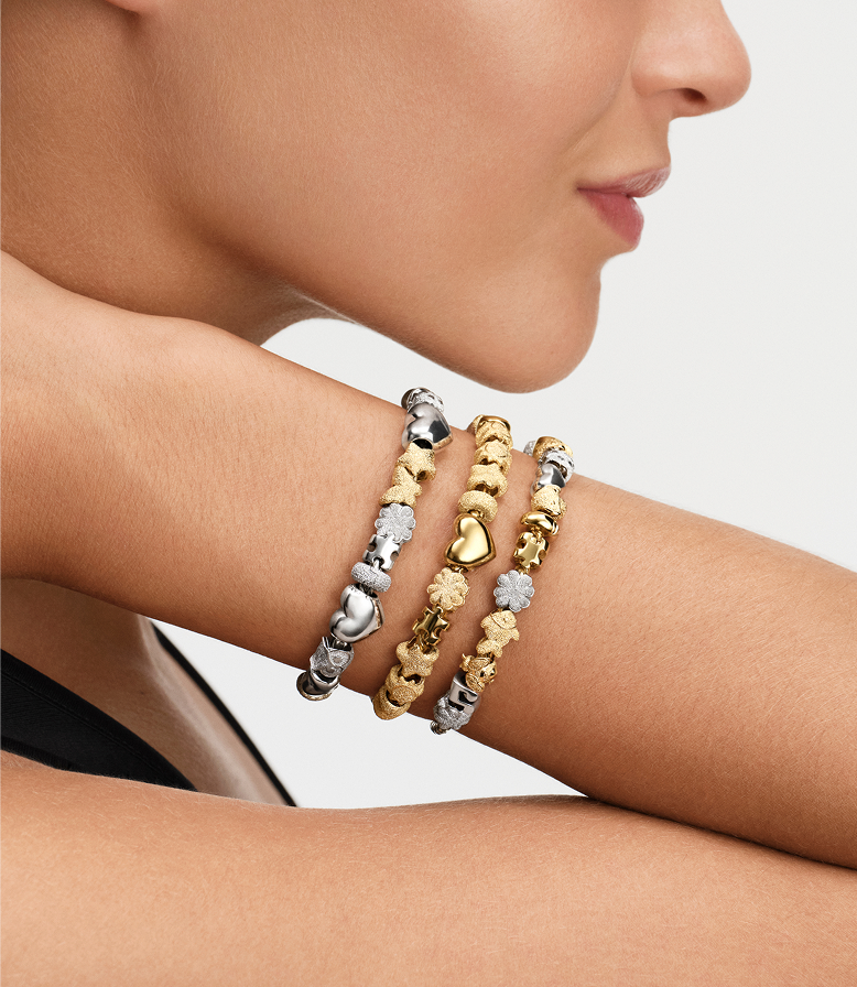 Model wears a bracelet stack featuring silver and gold minis