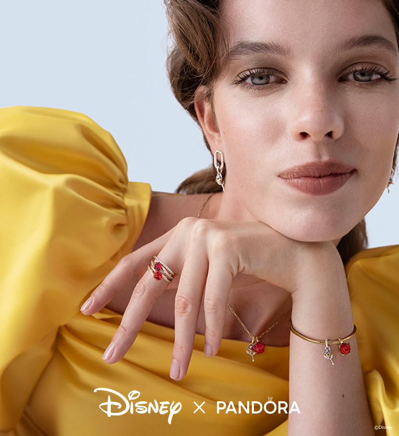 A model dressed as Disney’s Princess Belle wears stacks of rose charms and rings
