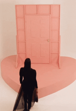 Woman opening door revealing stack of boxes