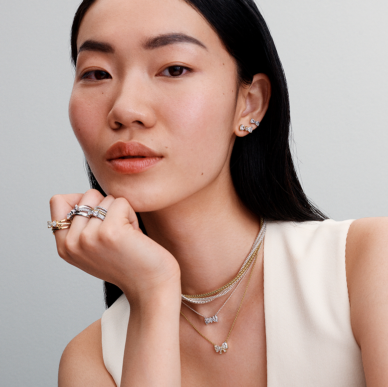 Model wearing Pandora Timeless bow motif rings, earrings and necklaces