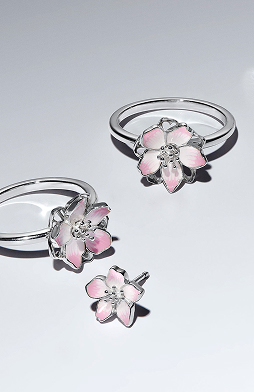 Cherry blossom sterling silver rings and earrings on surface
