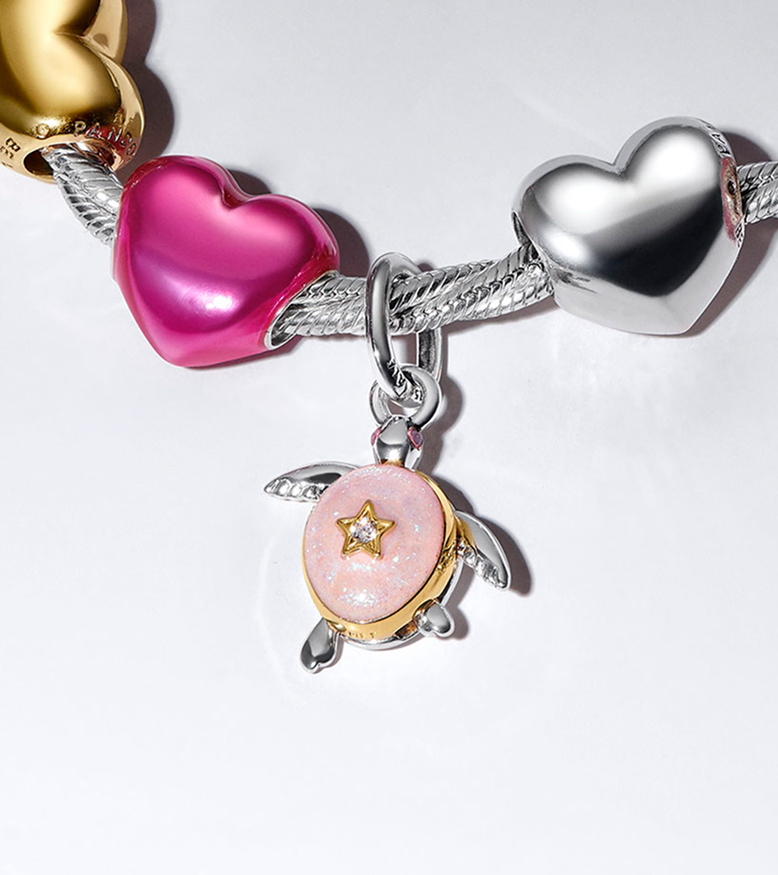 A close-up of the turtle charm on a snake chain