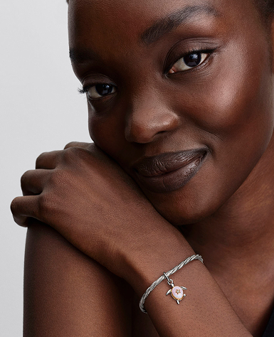 The turtle charm styled on a snake chain bracelet