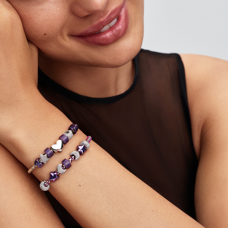 Model wears a bracelet stack featuring purple and silver minis