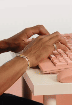 Model wearing Pandora jewellery typing on computer