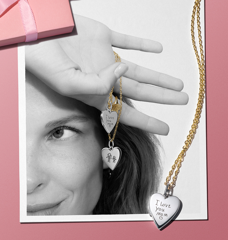 A modell gravírozott függő nyakláncot tart a kezében