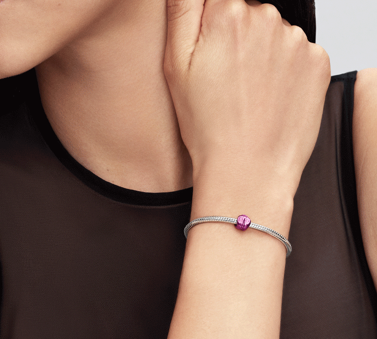 Model wears bracelet featuring a pink ladybird mini