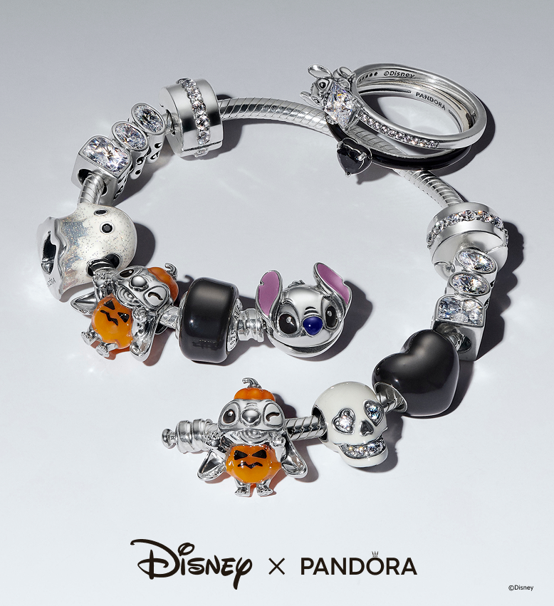 Disney’s Stitch and Halloween jewellery showing rings and a charm bracelet stacked with a selection of Disney’s Stitch and Halloween charms
