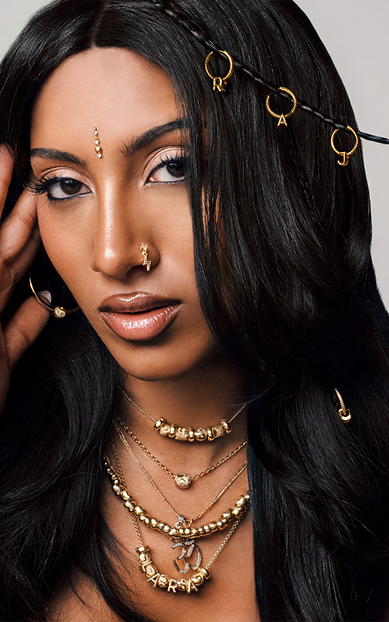 Lara styles our new globe charm with other 14k gold-plated Pandora Minis for a fully loaded look