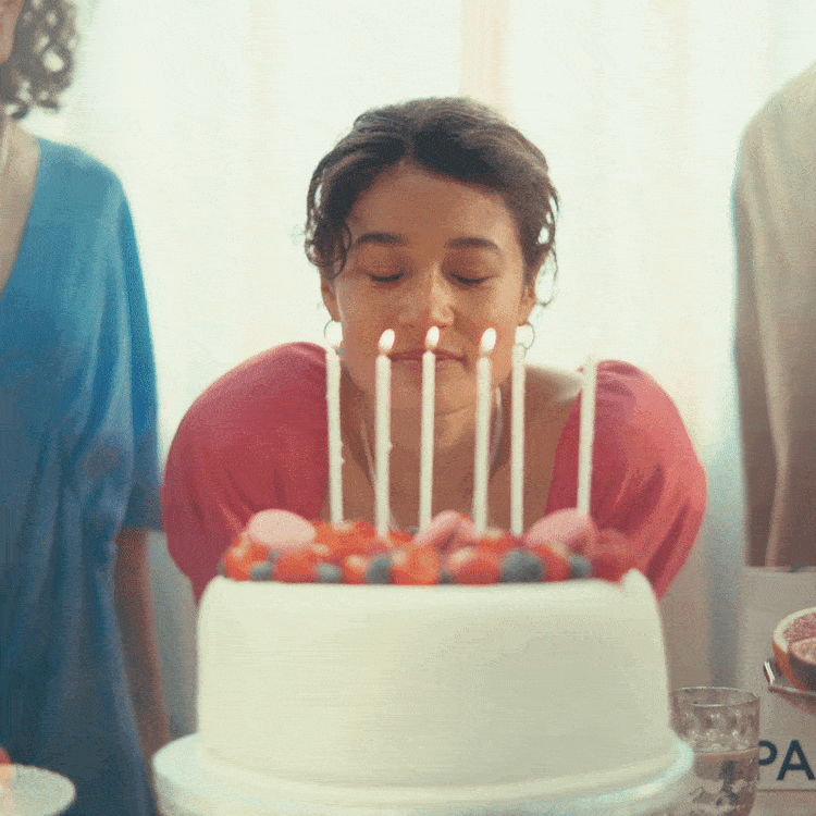 Woman blowing out candles on cake